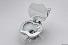 an open toilet bowl sitting on top of a tiled floor