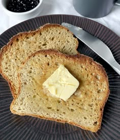 two pieces of bread on a plate with butter