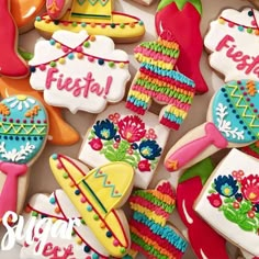 some decorated cookies are sitting on a table with the words fiesta written in it and other decorations