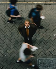 an overhead view of people walking down the street, with one man wearing a suit and tie