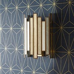 an art deco wallpaper with gold lines and geometric shapes on it's blue background