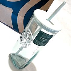 a starbucks cup with a straw in it next to a bag