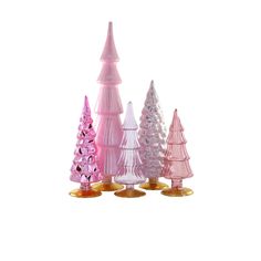 small pink and white christmas trees with gold bases on each one, set against a white background