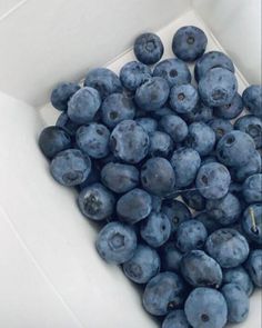 a pile of blueberries in a white bowl