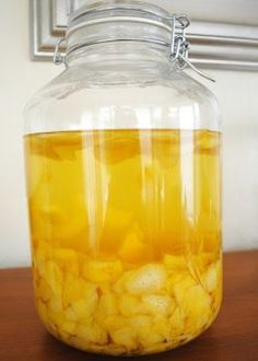 a glass jar filled with liquid sitting on top of a wooden table