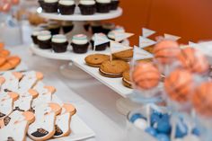 an assortment of cookies and cupcakes displayed on trays