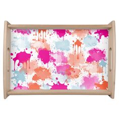 a tray with pink and blue paint splattered on it, in front of a white background