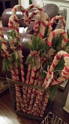 a basket filled with candy canes on top of a wooden floor next to a couch