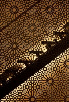 an intricately designed ceiling in the middle of a building with light coming through it