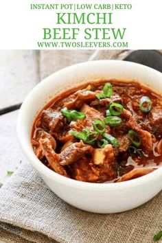 a white bowl filled with beef stew on top of a table