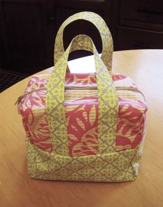 a bag sitting on top of a table next to a wooden table with a drawer