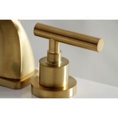 a gold faucet and soap dispenser on a white counter