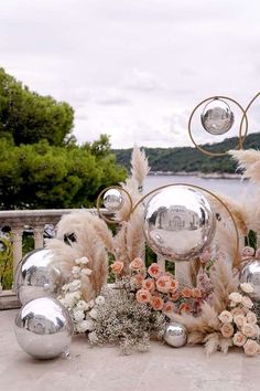 a table topped with lots of silver balls and flowers