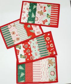 four placemats with christmas designs on them sitting next to each other in front of a white table