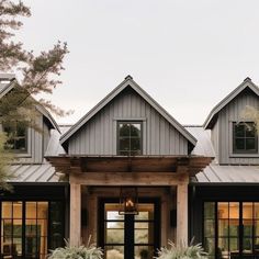 the front entrance to a large house with lots of windows and plants on the lawn