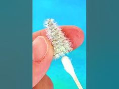 a hand holding a tiny toothbrush in it's palm