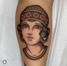 a woman's face with flowers on her head is shown in this tattoo design