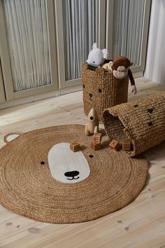 a teddy bear rug with two stuffed animals in the middle and a basket on the floor