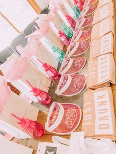 there are many paper bags lined up on the table with ribbons and bows around them