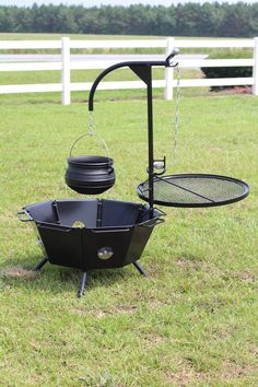 a black bird feeder on top of a grass covered field