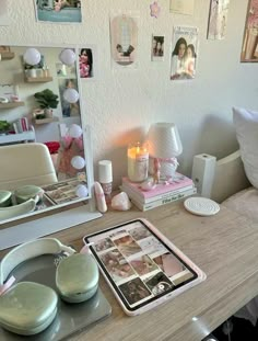 a desk with a mirror, candles and pictures on the wall