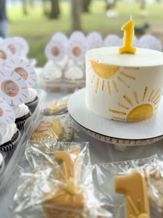 a birthday cake and cupcakes on a table