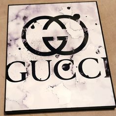 the gucci logo is displayed on a white and black tile