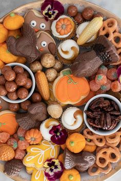 a platter filled with lots of different types of cookies and candies on top of each other