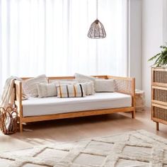 a living room filled with furniture and a white rug on the floor in front of a window