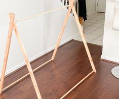 a woman standing in front of a wooden frame on top of a hard wood floor