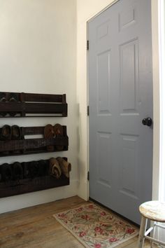 there is a gray door and some shelves on the wall