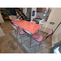 a pink table and four chairs in a room