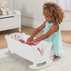 The KidKraft Lil' Doll Cradle has a classic, vintage feel, thanks to the scalloped trim and fancy filigree cutouts. Kids can gently rock their baby dolls from side to side to give them sweet slumber. This wooden doll furniture cradle is an ideal addition to a baby doll collection so kids can role play taking care of babies. Makes an excellent gift, especially when paired with doll accessories, such as bottles, diapers, and doll clothes (not included). The white finish fits in well with other dol Baby Doll Cradle, Baby Doll Crib, Doll High Chair, Taking Care Of Baby, Rocking Cradle, Doll Cradle, Doll Crib, Scalloped Trim, Wooden Dolls