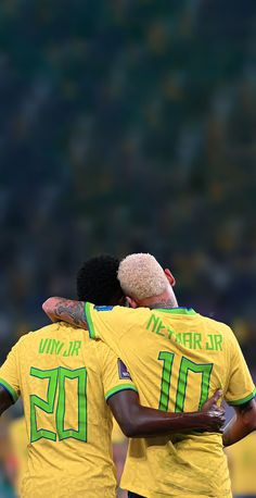 two soccer players hugging each other on the field