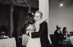 a bride and groom hugging at their wedding reception