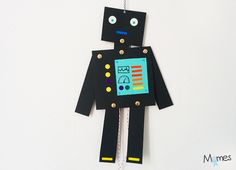 a robot made out of paper hanging on a wall