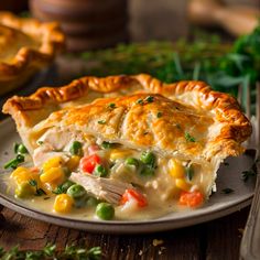 a chicken pot pie with peas and carrots on a plate