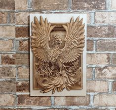 a wood carving of a bird on a brick wall