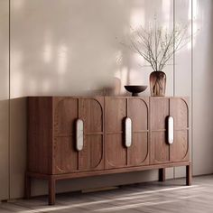 a wooden cabinet with two vases on top