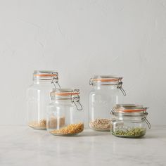 three glass jars filled with different types of food on a counter top next to each other