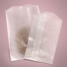 two pieces of white paper on a pink background