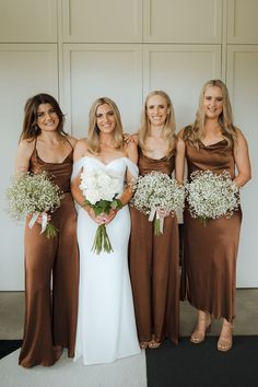 the bridesmaids are wearing brown dresses and holding bouquets with baby's breath