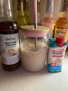 there are many different types of drinks in the jar on the counter top, including peanut butter and coffee