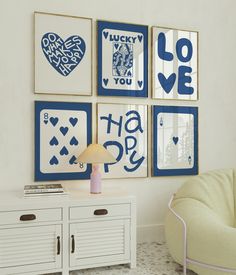 a living room with pictures on the wall and a chair in front of a table