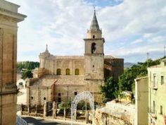 an old church with a fountain in the foreground and another building in the background