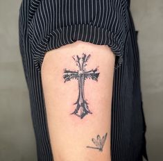 a person with a cross tattoo on their arm