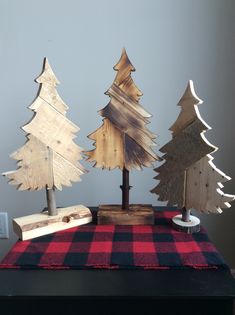 three wooden christmas trees on top of a table