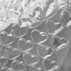 clear heart shaped plastic containers are stacked on top of each other in this black and white photo