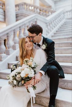 a bride and groom are sitting on the stairs