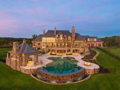 a large house with a pool in the front yard and an outdoor fireplace on the side